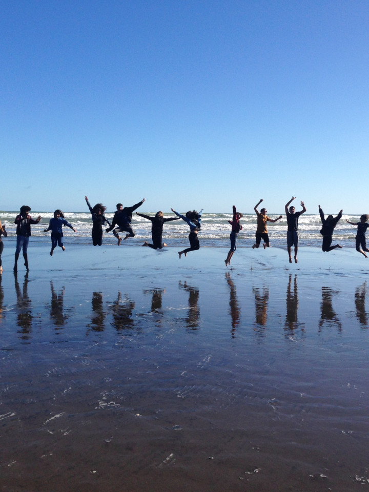 In die Luft springende Schüler am Meer.