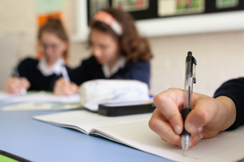 SchülerInnen im Klassenzimmer bei der Bearbeitung einer Aufgabe.
