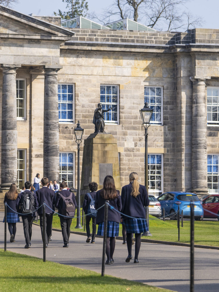 Schülerinnen der Dollar Academy in Schottland gehen auf das historische Hauptgebäude zu.