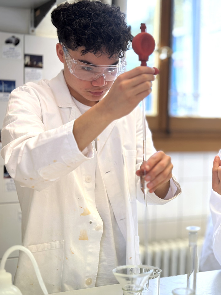 Junge und Mädchen im Schullabor beim Experimentieren.