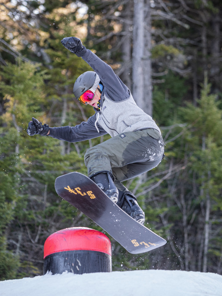 Snowboarder beim Sprung über Rampe im Sunday River Ski Resport, Maine.