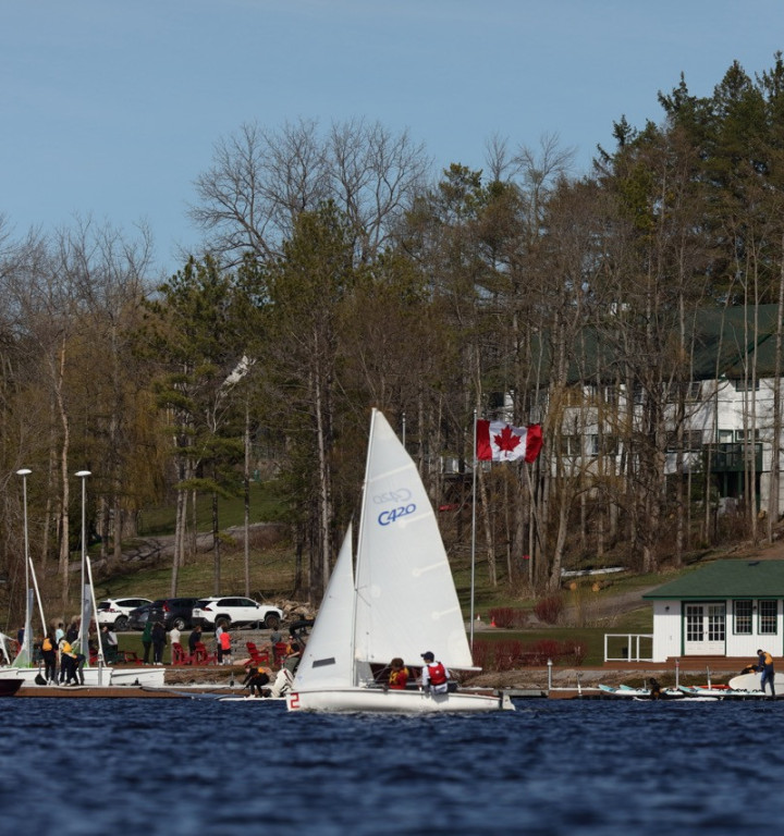 Eine Segelregatta mit Schulcampus im Hintergrund