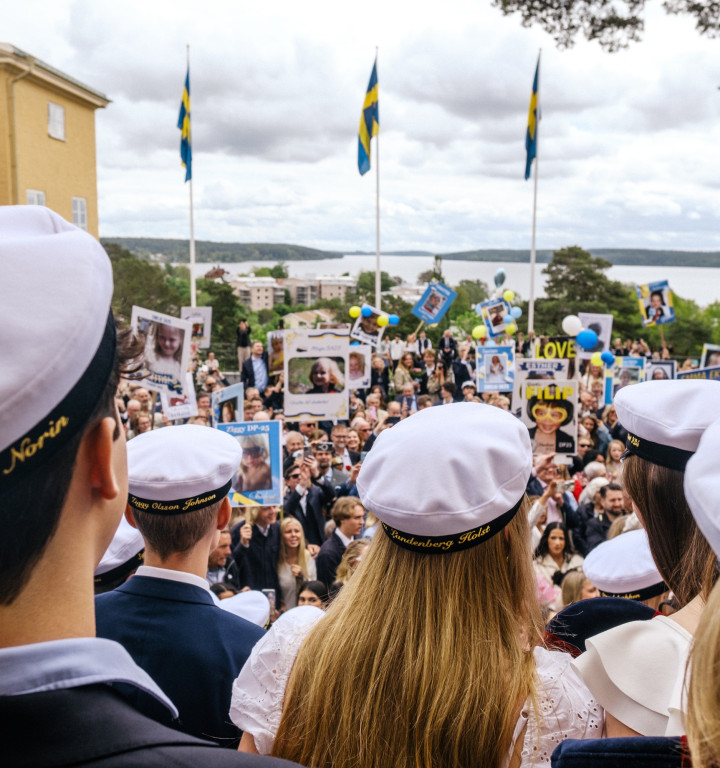 Schülerinnen und Schüler in Kadettenuniform mit Kapitänsmütze vor dem Schulgebäude