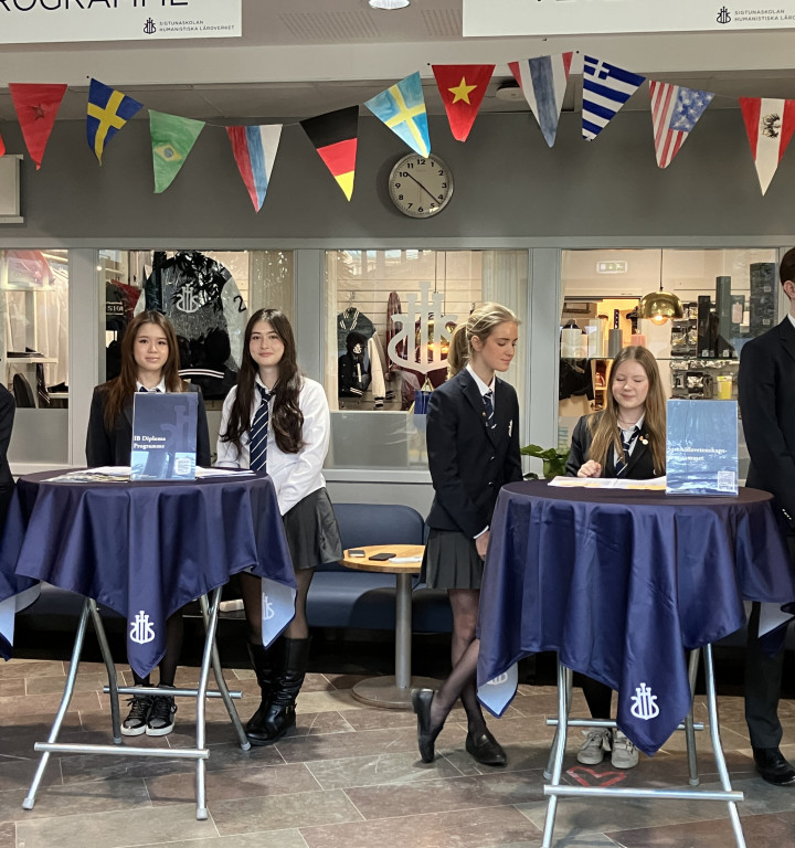 Schülerinnen und Schüler in Uniform vermutlich beim International Day, man sieht viele unterschiedliche Flaggen